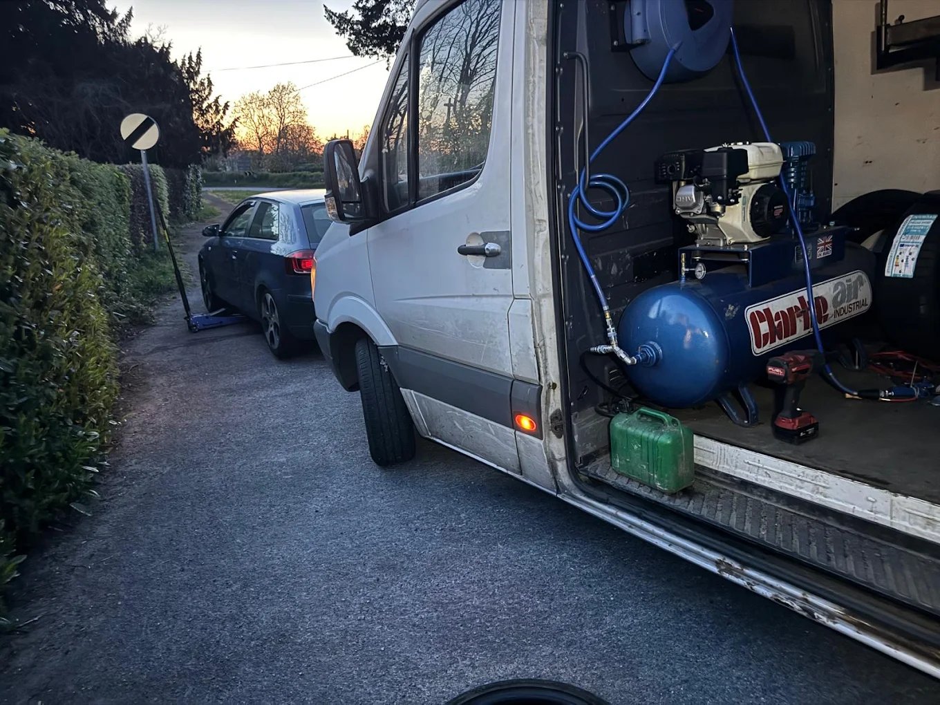 Mobile tyre fitting van with technician working on vehicle